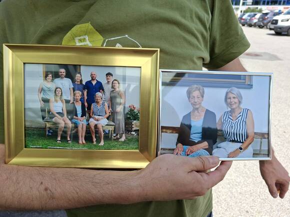 Zwei gerahmte Familienfotos, eines mit einer größeren Familie und eines mit zwei Frauen