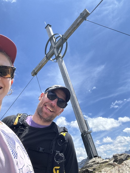 Andreas und seine Frau vor einem Gipfelkreuz in Tirol